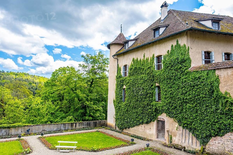 Wildenstein Castle with ivy-covered walls and a well-kept garden against a cloudy sky, Bubendorf, Canton Basel-Landschaft, Switzerland