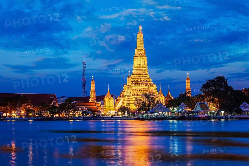 Buddhist temple Wat Arun (Wat Arun Ratchawararam Ratchawaramahawihan) (Temple of Dawn) famous tourist landmark illuminated in the evening. Bangkok, Thailand