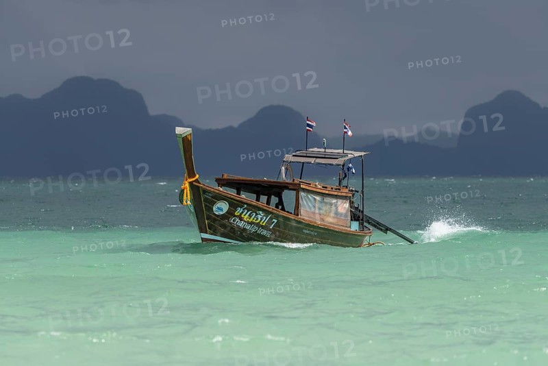 Longtail boat travelling fast to the beach, behind it an approaching thunderstorm, Koh Ngai Island, Andaman Sea, Satun Province, Southern Thailand, Thailand
