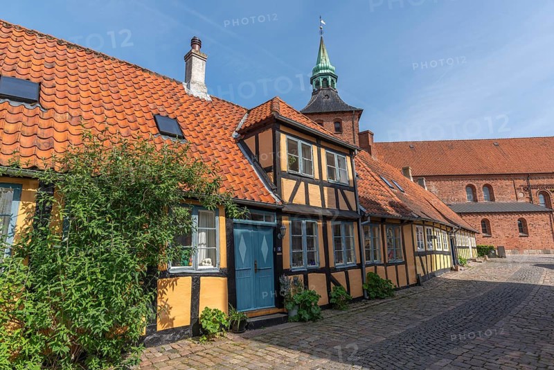Svendborg Old Town, yellow, half-timbered house with St. Nicolai Church, cobblestones, entrance door, Fyn, Fyn Island, Denmark