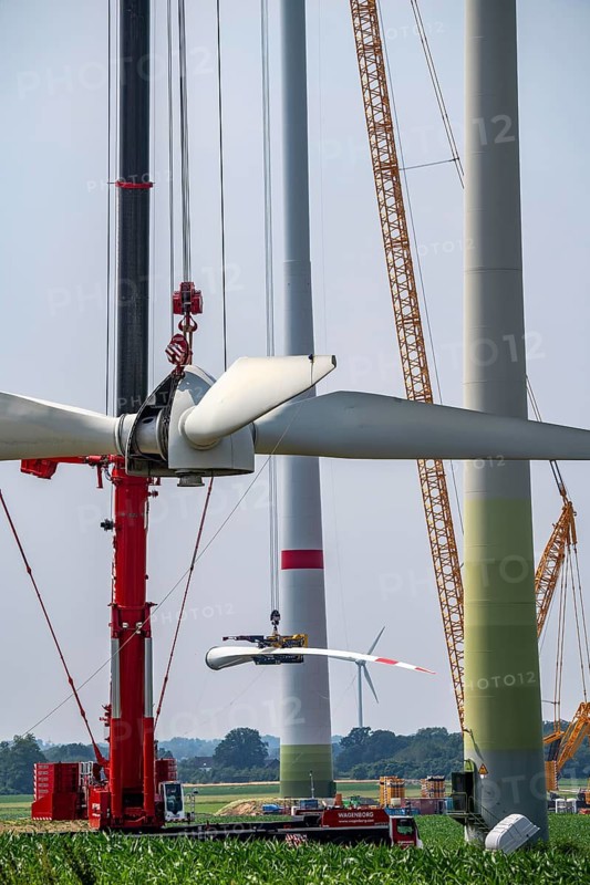 Dismantling of a wind power plant in a wind farm near Issum, 9 older wind turbines from the manufacturer Enercon (model series E-58), front, blades being dismantled, were in operation for over two decades, will be replaced by a total of four Enercon E-160 turbines, rear, assembly of the first blade, with a total output of 22 megawatts, Lower Rhine, North Rhine-Westphalia, Germany