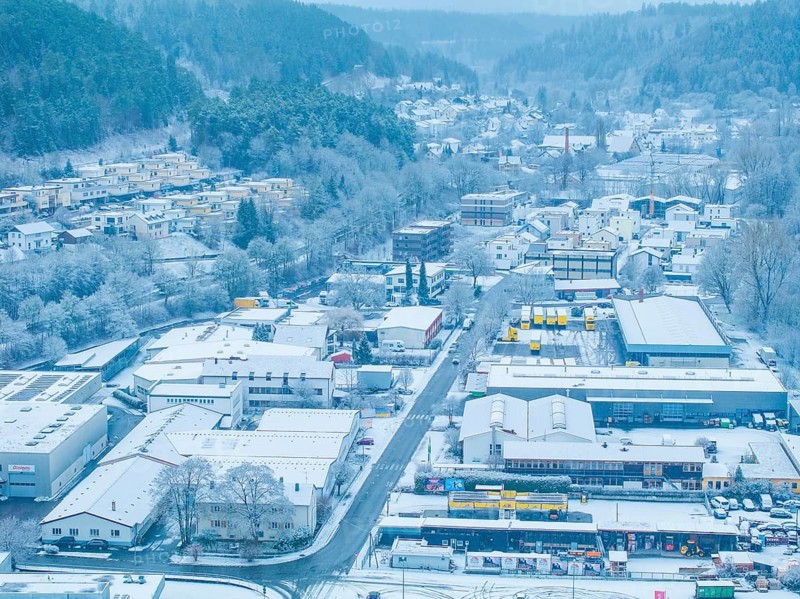 Snowy town from the air with fog-filled hills in the background, quiet winter atmosphere, Nagold, Black Forest, Germany