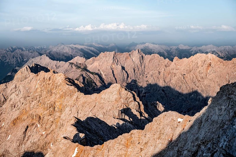 Impressive rocky mountain landscape, steep mountain ridge, Jubiläumsgrat and Wettersteingrat, mountain panorama from the summit of the Zugspitze, alpenglow at sunset, Northern Limestone Alps, Wetterstein range, Bavaria, Germany