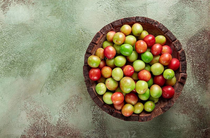 Cherry plum tkemali, fruit, plum variety, in a wooden plate, Georgian cuisine, top view, no people