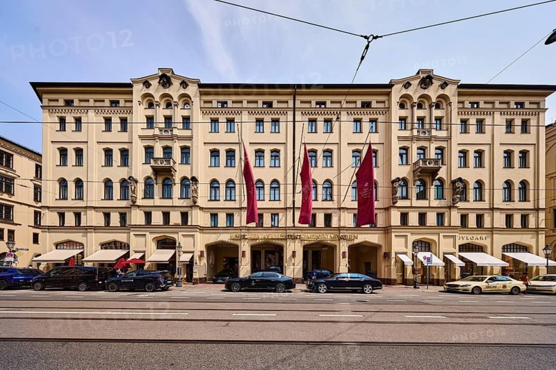 Hotel Vier Jahreszeiten Kempinski Munich, historic commercial building, Maximilian style, parking strip with cars, pale blue sky, cumulus clouds, cirrostratus clouds, slightly diffused and sunny light, Maximilianstraße street, Munich, state capital, district-free city, Bavaria, Germany