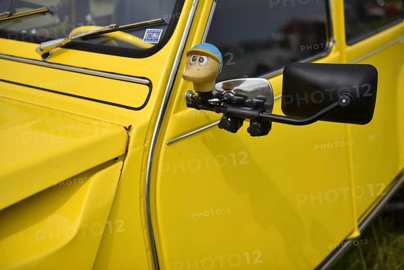 Close-up of a yellow Citroen with side mirror and figure sticker, Citroën 2CV at a duck meeting in Kropp, Schleswig-Holstein, Germany