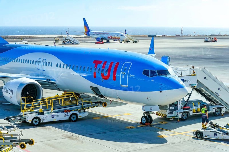 Santa Cruz, Tenerife, Canary Islands, Spain - TUI aircraft Boeing 737 Max 8 (Dakar G-TUPD) ready for boarding. Aeropuerto de Tenerife Sur TFS. In the back is a Jet2Holiday aircraft
