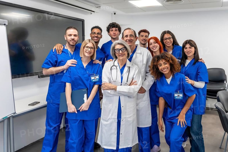Doctors and interns from different generations and backgrounds smiling for a group portrait in a modern healthcare facility, symbolizing teamwork, education, and professional development