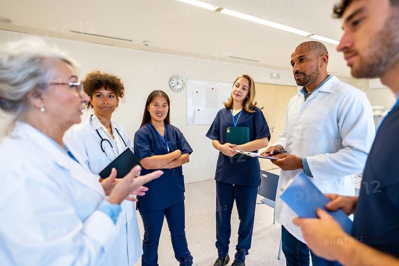 Diverse medical professionals collaborating, sharing expertise, and reviewing patient information during a productive meeting in a hospital setting