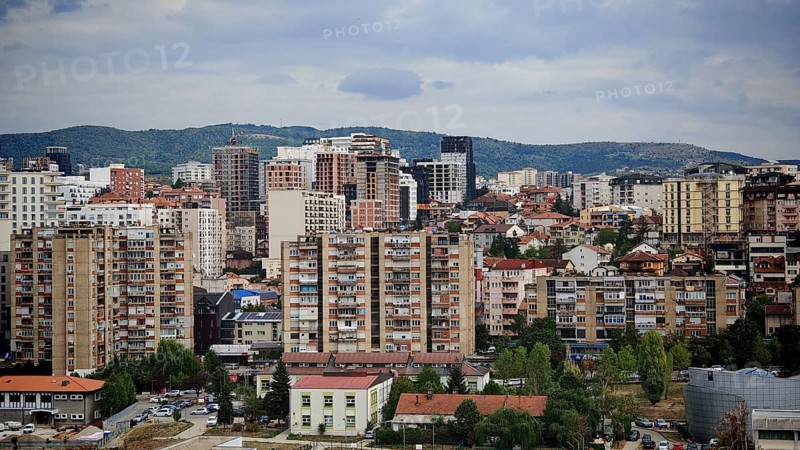 Panorama of a city with densely built residential buildings and a cloudy sky, Pristina, Kosovo