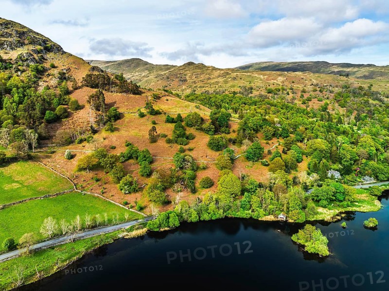 Farms and Mountains over road A591 from a drone, Grasmere Lake, Grasmere, Ambleside, Lake District, Westmorland, Cumbria, UK