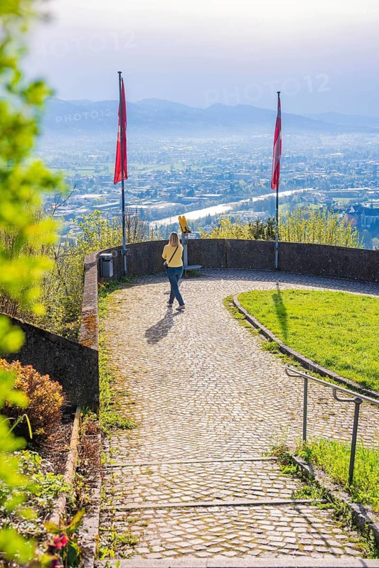 Woman walking along a path with a view of the urban landscape, Bregenz, Austria