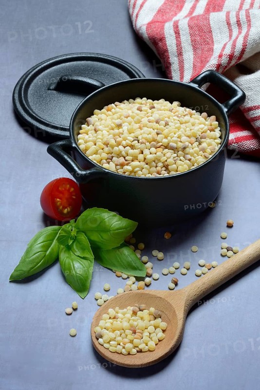 Fregola in pots and spoons, uncooked, pasta variety from Sardinia, Italy