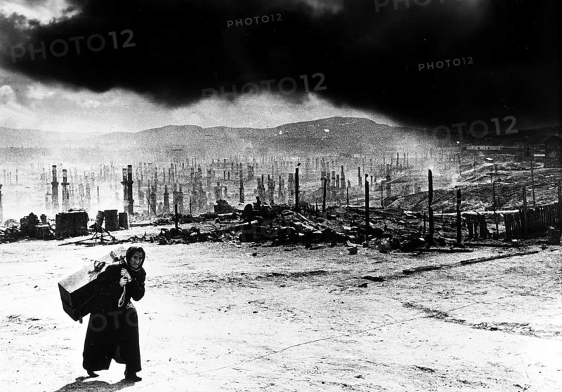 Scorched Earth, Northern Front, Murmansk, Soviet Union 1941 Variant 1 with manipulated skies J. Chaldej about this photo: 'Hitler had said: 'Murmansk must be taken. ' He wanted to prevent the British from supporting the Soviet Union. Murmansk was bombed for a year. On June 22, 1942, Hitler gave the order to burn Murmansk down for good. The city consisted primarily of wooden houses. 350, 000 incendiary bombs were dropped for a day. I discovered the old woman with her suitcase after one of the bombings in 1941. She saw that I had a camera, put down the suitcase and said: 'Aren't you ashamed to record our misfortune? '