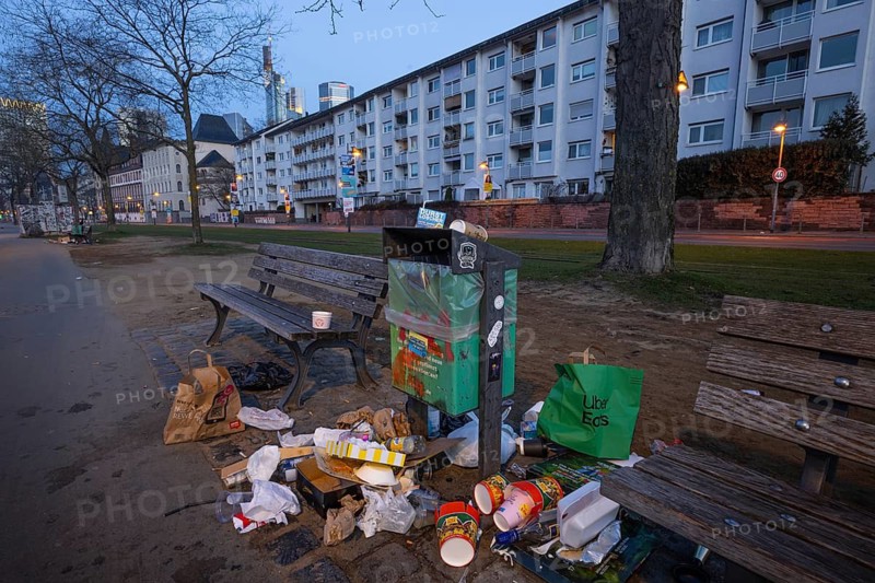 Rubbish is lying around a trash can that stands between two benches on the banks of the Main in Frankfurt. The increasing littering of Frankfurt's city center is an unresolved problem that has existed for a long time, Frankfurt am Main, Hesse, Germany