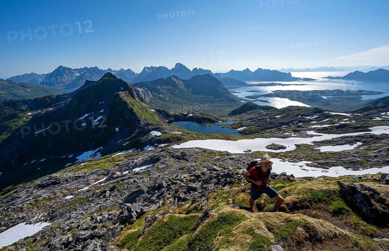 View of mountains and fjord landscape, mountaineers at the summit of Rundfjellet, Austenesfjord and Hellskarvatnet lake, Svolvaer, Nordland, Norway