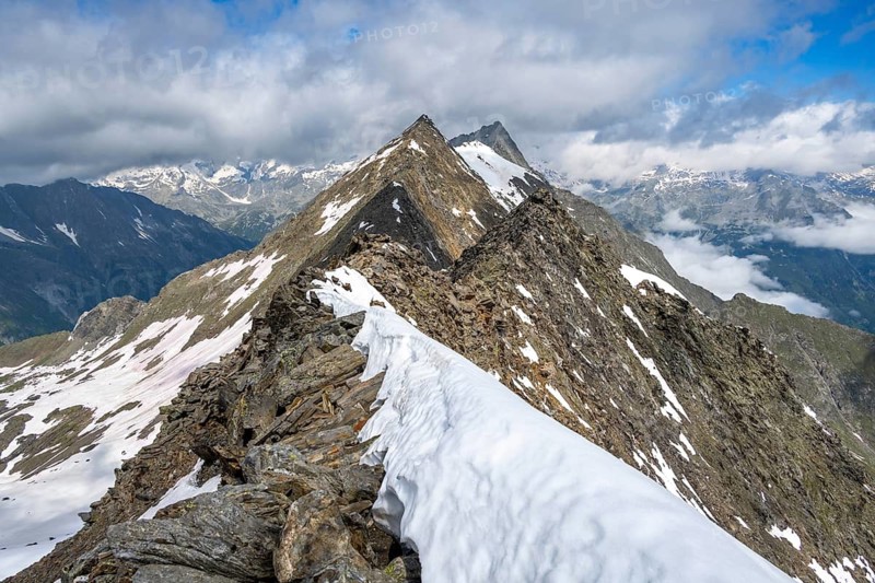 Snow-covered mountain ridge with view of surrounding peaks under a clear blue sky, summit of the Schönbichler Horn, Berliner Höhenweg, Zillertal Alps, Tyrol, Austria