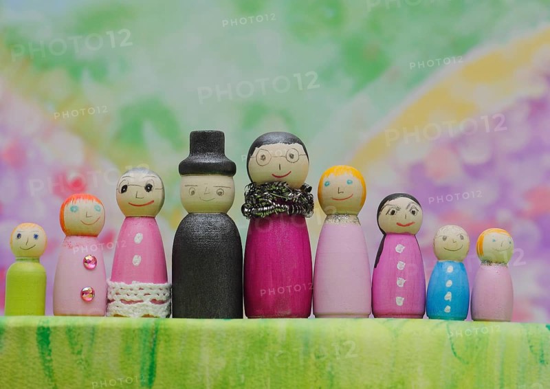 Nine funny painted wooden cones man and woman large and small in front of a colourful painted background, North Rhine-Westphalia, Germany