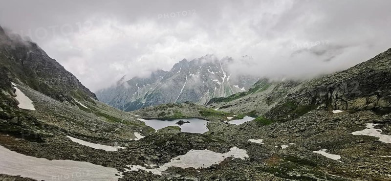 Cold, rainy mountain panorama with melting snow and cloudy sky, hiking, Rysy, High Tatras, Slovakia