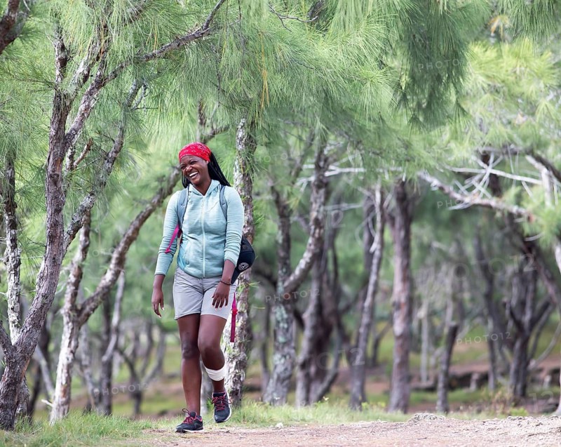 Mauritian woman, 35 years old, laughing, walking through a casuarina forest, Rodrigues Island, Mauritius