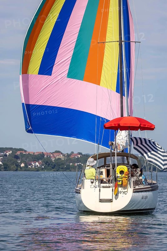 Sailing party on Lake Constance, yacht with colourful foresail and sunshades, Immenstaad, Baden-Württemberg, Germany