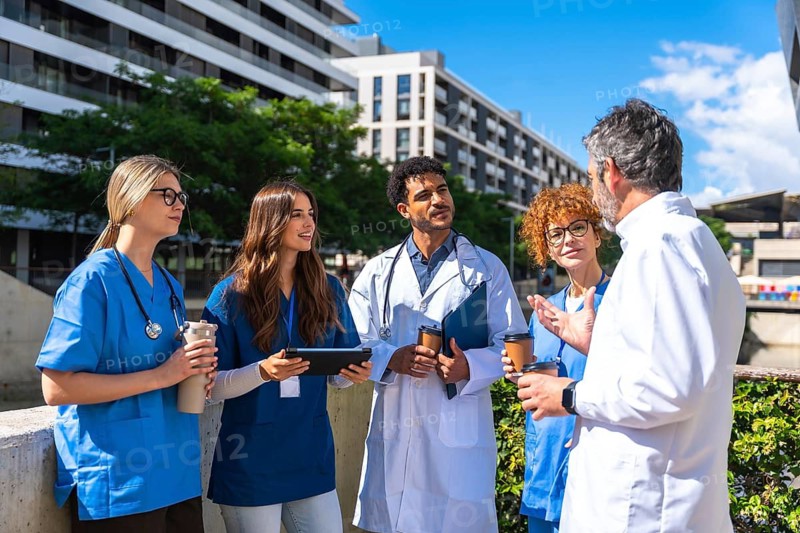 Diverse team of doctors and nurses collaborating during a casual outdoor meeting, exchanging ideas and planning for patient care in an urban environment