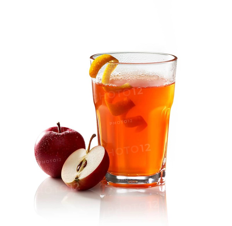 Hot apple punch on a white background, apple, half of apple and orange zest as garnish, studio shot