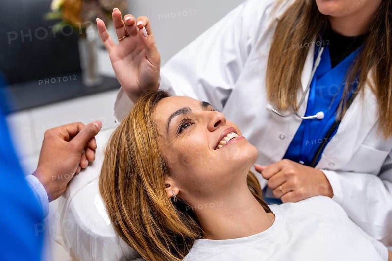 Patient smiling confidently while a doctor performs a medical examination, symbolizing trust, health, and a positive healthcare experience in a clinic setting