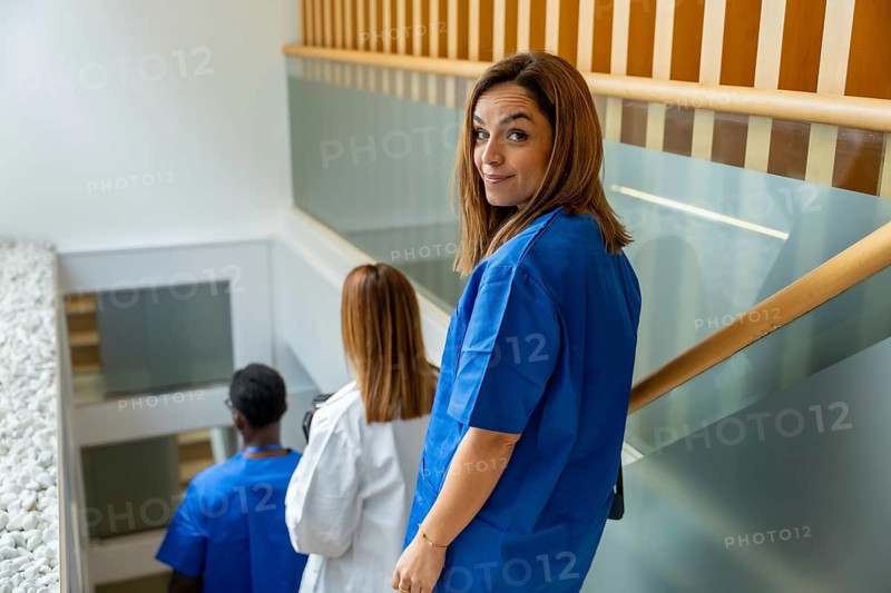 Healthcare professionals, including a doctor and nurses, moving through a modern hospital facility, representing teamwork and dedication in the medical field