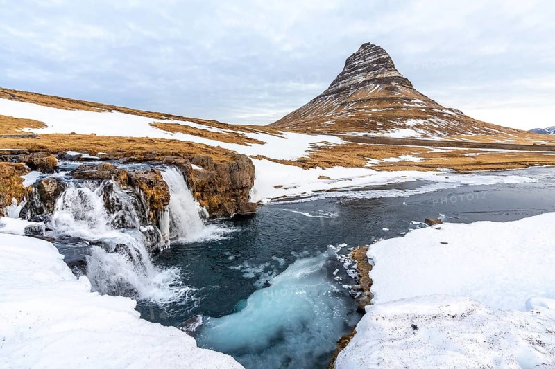 Beautiful waterfall with snow on the famous Kirkjufell mountain in winter in Iceland