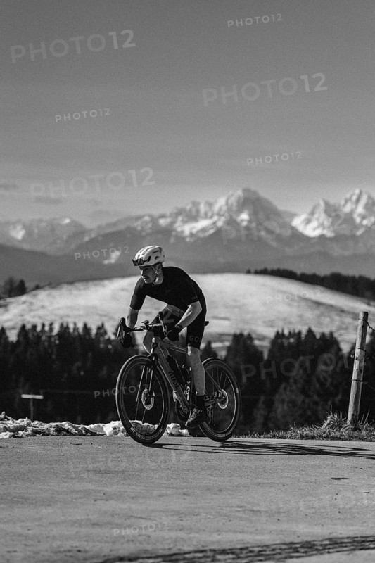 Road bike rider in spring near Halblech in the Allgäu in front of a picturesque backdrop of the Alps, Bavaria, Germany