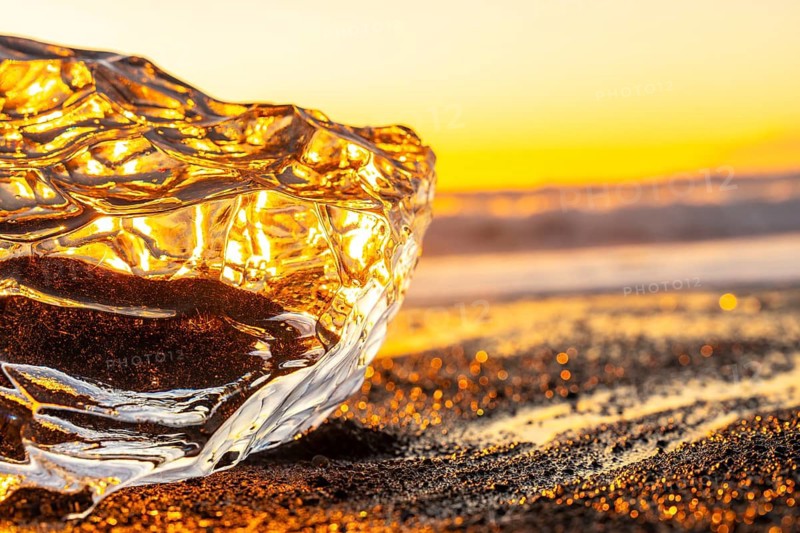 Clear ice at sunrise on Diamond Beach next to Jokulsarlon in winter in Iceland