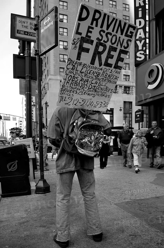 Man carrying an advertising sign for a driving school, New York City, USA