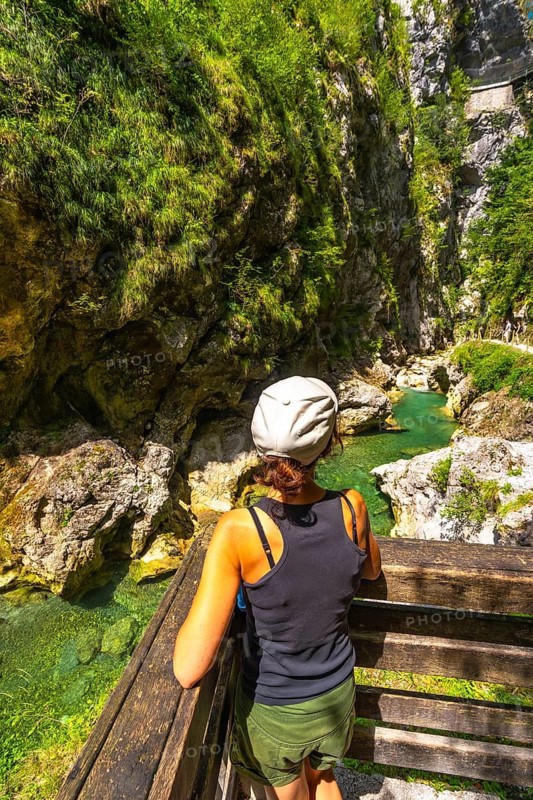 Woman admiring tolmin gorges canyon with thermal spring in slovenia, europe, during sunny summer day