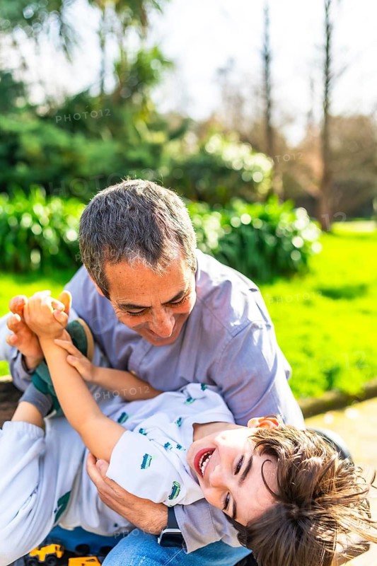 Grandfather and grandson enjoying a playful moment together in a sunny park, creating cherished memories