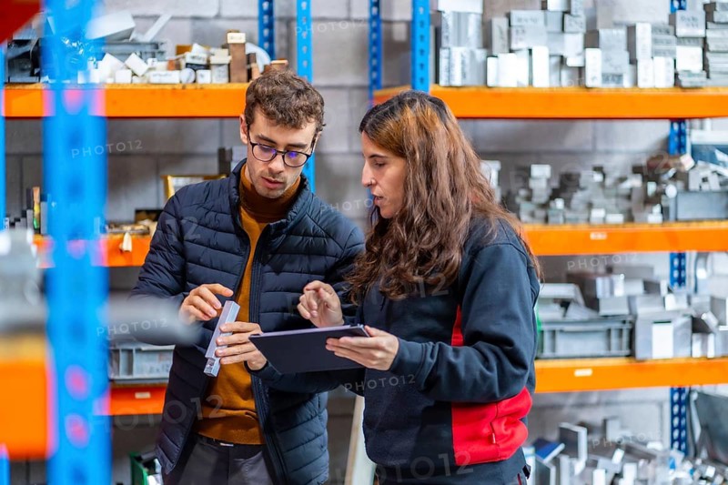 Engineers working on a stock room of a cnc factory using a digital tablet