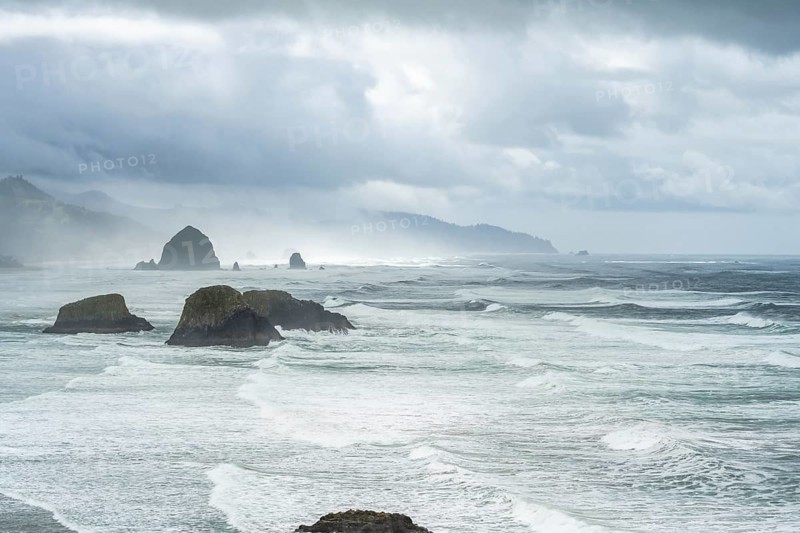 A rugged coastal landscape with rocks in the sea and a cloudy sky, Indian Beach, Oregon, USA, North America