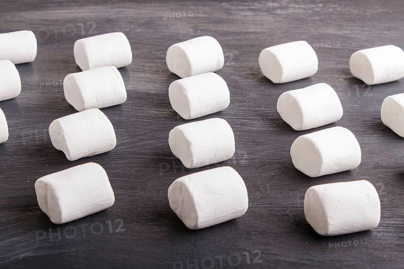 Set of marshmallows on black wooden background. top view, flat lay. geometric pattern