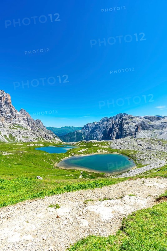 Breathtaking view of alpine lakes nestled amidst the majestic peaks of the dolomites, inviting hikers to explore the stunning natural beauty of italy. Laghi dei Piani
