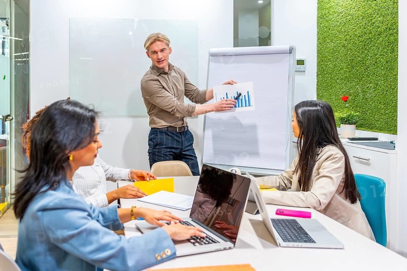 Diverse team of managers analyzing growth strategies during a productive meeting in a modern coworking office