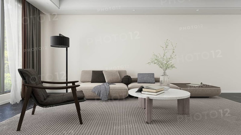 Cozy, modern living room featuring a neutral color palette. Includes a comfortable sofa, elegant armchair, contemporary table, and natural light from large windows