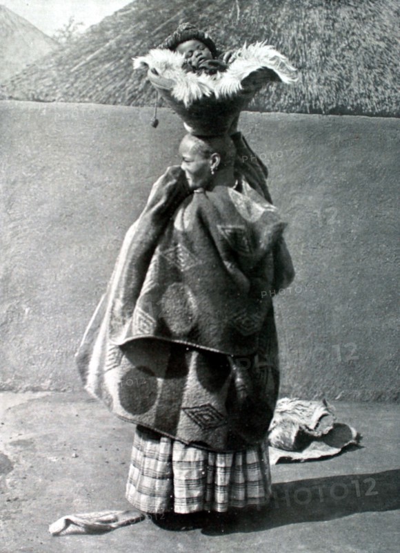 A baby out for a stroll in a Peruvian village (1913)