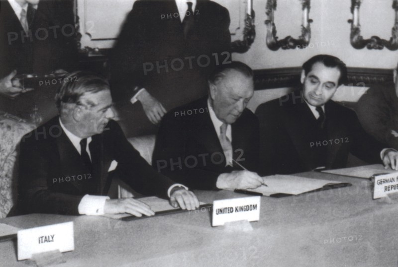 October 1954, London and Paris agreements. Adenauer, surrounded by Eden and Mendès-France, signs the agreement on rearmament and German sovereignty.