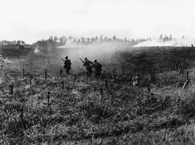 Soldiers from the American infantry advancing behind a tank near Beauquesnes