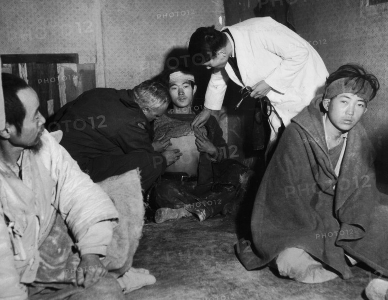Refugees from Koje island. Doctor Henri Meyer examines a refugee suspected to have contracted typhus