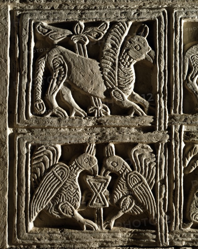 Griffin and birds facing each other around the Chalice of life