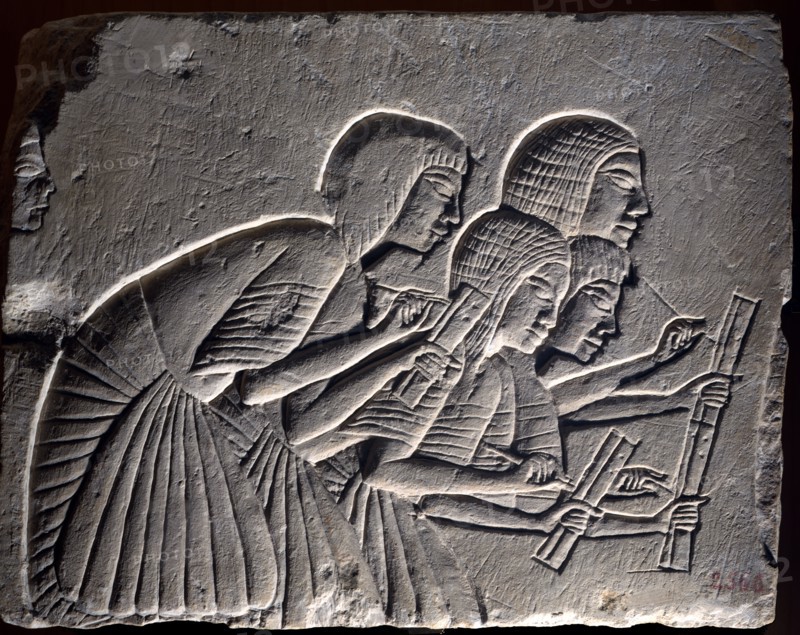 Fragment from funerary wall from Nineteenth dynasty: Group of scribes intently writing down a dictation