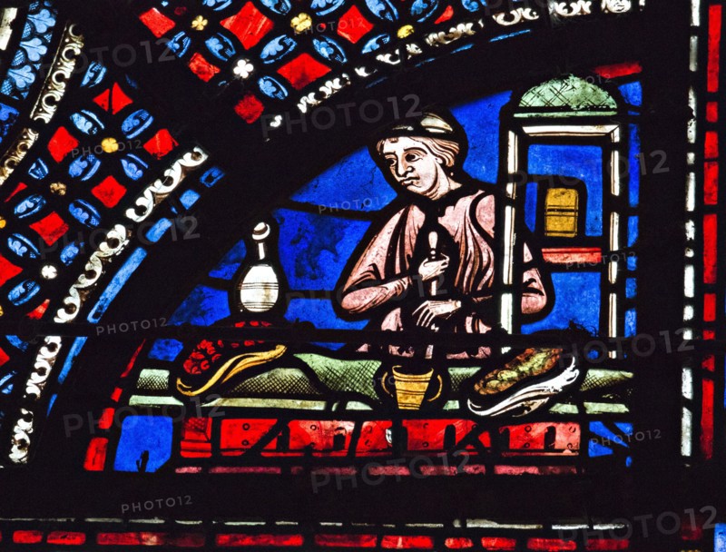Un apothicaire prépare une potion dans un mortier (vitrail de Chartres)
