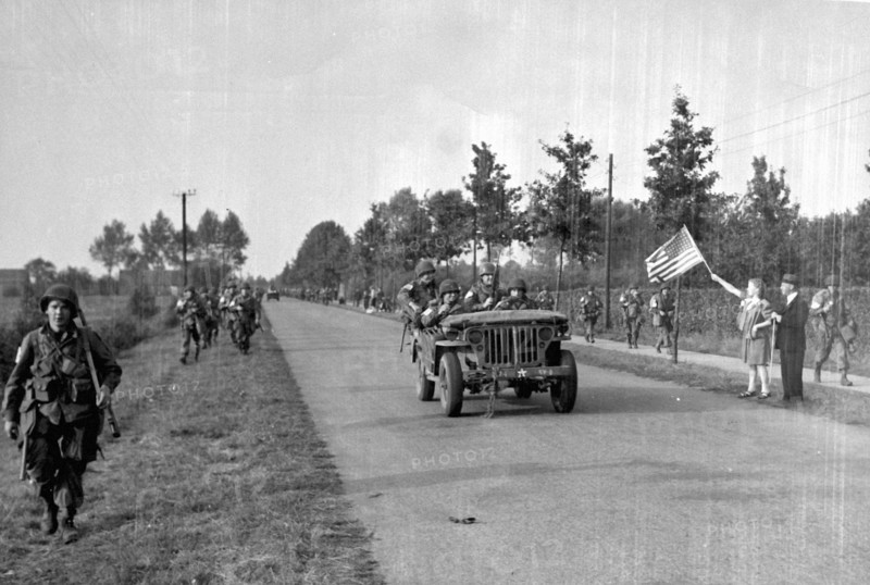 Dutch people wave an American flag at U.S Paratrooppers near Zon (Holland) Sept.18,1944
