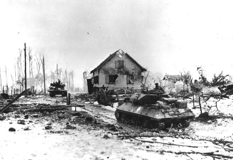 Des chars d'assaut français traversent la ville de Bettenhoffen ravagée par la guerre (France, janvier 1945).